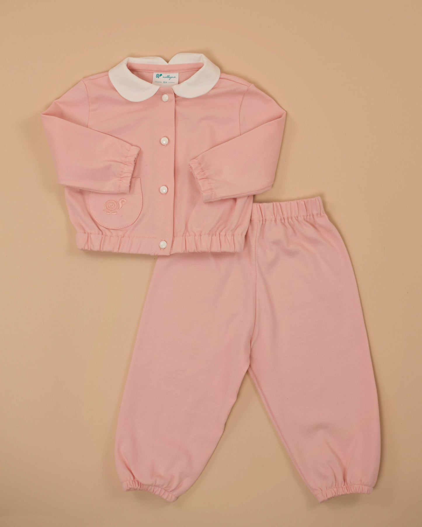 A baby girl's pink two-piece set with a white collar and a button placket, consisting of a sweatshirt and pants.